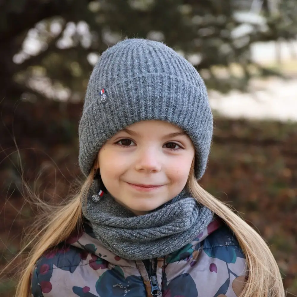 Bonnet Élie gris en maille côtelée porté par un enfant dans un environnement extérieur hivernal.
