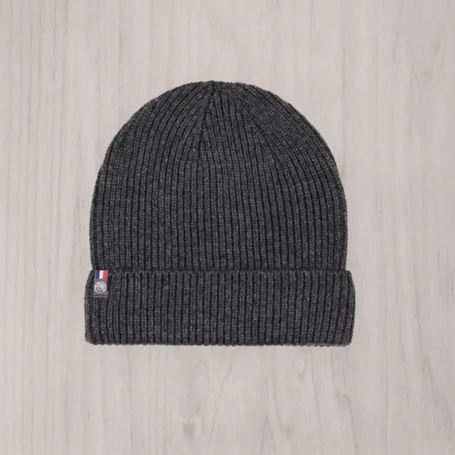 Bonnet enfant gris en maille côtelée présenté de face sur un fond clair.