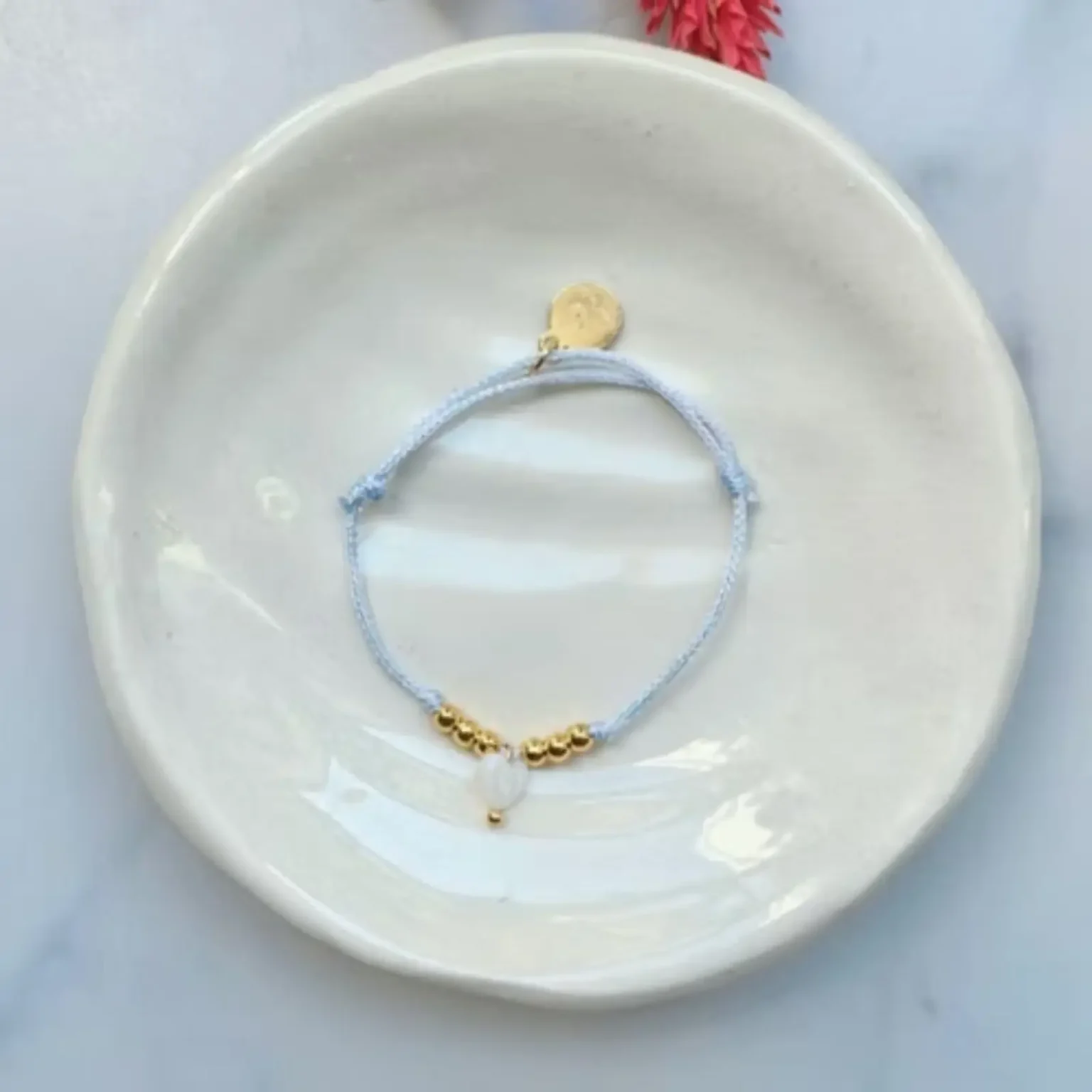 Bracelet enfant Les Câlines lilas avec cordon fin et petit cœur doré.