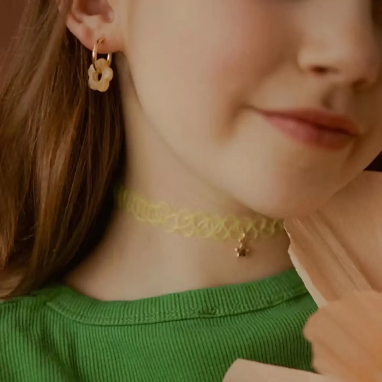 Boucles d'oreilles enfant Les Mini Flowers pêche portées à l'oreille.