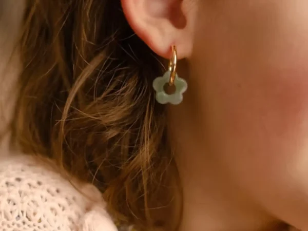 Boucles d'oreilles enfant Les Mini Flowers couleur eau portées à l'oreille.